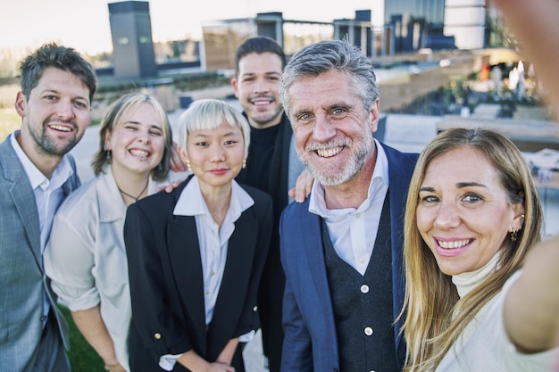 Selfie de um grupo de empresários felizes tirando fotos com um telefone