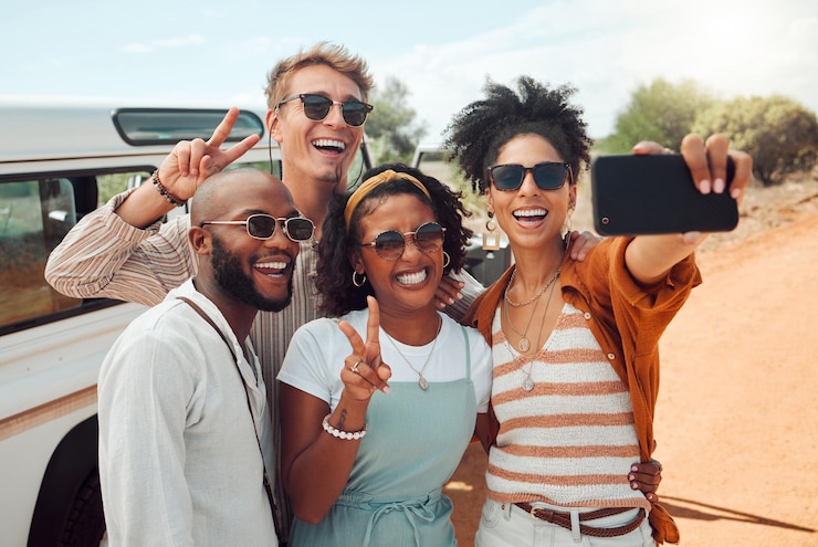 Foto selfie de diversidad y amigos en una aventura de viaje por carretera en un campo tomando una foto por teléfono vacaciones de viaje y grupo de personas con automóvil de teléfono inteligente y sonrisa en las caras felices en vacaciones en la naturaleza