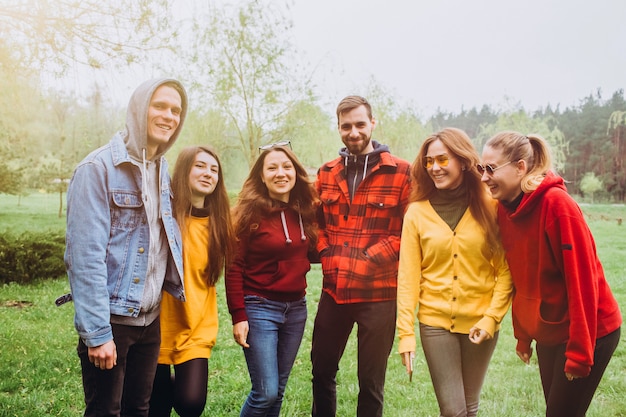 Selfie engraçada com os amigos. companhia de amigos alegres fazendo selfie e sorrindo em pé ao ar livre. as pessoas usam camisolas vermelhas e amarelas. jovens descansando na natureza, conversando e rindo