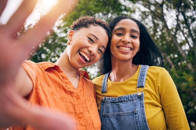 Selfie feliz e retrato de mulheres no parque para postagem on-line de mídia social e foto de perfil Amizade natureza e mulheres com mão tiram foto para férias de união e relaxamento ao ar livre