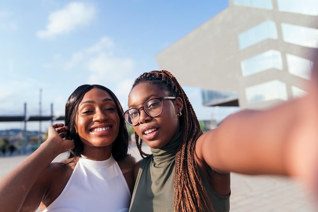 Selfie-Foto von zwei glücklichen jungen afrikanischen Frauen in der Stadt, Konzept von Jugend und Freundschaft, Kopienraum für Text