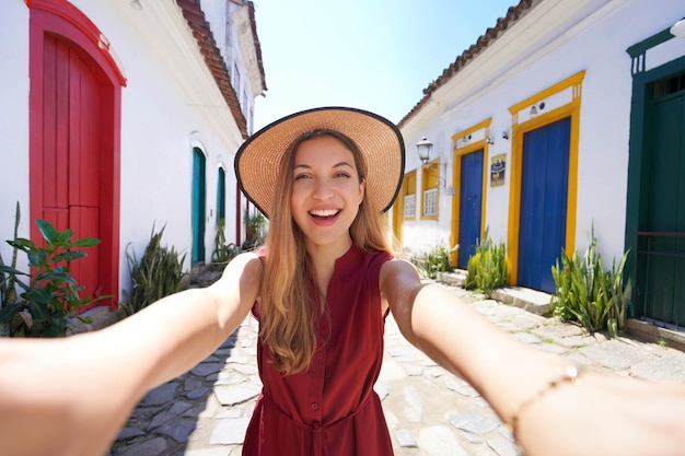 Selfie girl em Paraty, Brasil Jovem turista tirando auto-retrato na histórica vila colorida de Paraty, Rio de Janeiro, Brasil