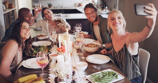 Selfie jantar e festa com amigos comendo juntos para uma celebração ou evento de ano novo Festa em casa e refeição com um grupo de amigos homem e mulher sentados à mesa para uma reunião social