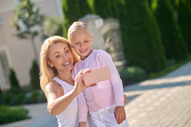 Selfie. Junge Frau und ein Mädchen machen Selfie und lächeln