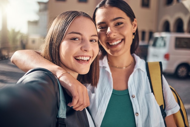 Selfie-Lächeln und Studenten auf dem Campus mit einer Umarmung, die sich auf die Schule und die Erinnerung während der Ausbildung freuen Fröhliches Universitäts- und Gesichtsporträt von Freundinnen mit einem Foto am College zusammen mit Glück