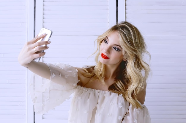 selfie maquillaje rubia / modelo de maquillaje hace selfie en teléfono, concepto estilo glamour moda, maquillaje