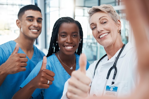 Foto selfie médico y estudiantes con pulgares arriba retrato en el hospital para el éxito diversidad y atención médica trabajo en equipo interracial y acuerdo de profesionales médicos con una sonrisa para la cooperación