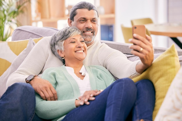 Selfie, pareja feliz y madura en el sofá con una sonrisa para publicar fotos de perfil en las redes sociales y recuerdos. Amor matrimonial y hombre y mujer toman fotos en la sala de estar para establecer relaciones y relajarse.