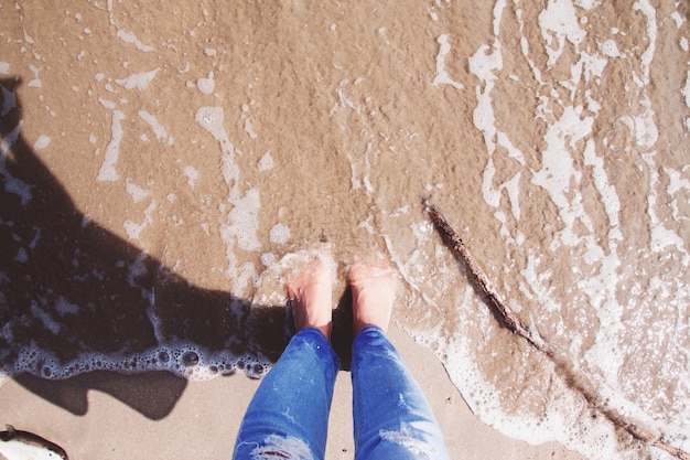 Selfie de pies, mujer de pie en la playa