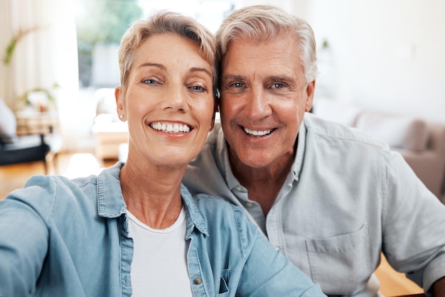 Selfie-Porträt eines älteren Paares in der Lounge zu Hause für Liebespflege und entspannten Tag zusammen Gesichter von lächelnden Männern, glückliche Frau und Rentner, die Zeit für Videoanrufe und enge Ehebande genießen