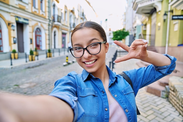 Selfie retrato de hermosa adolescente alegre al aire libre en la calle de la ciudad