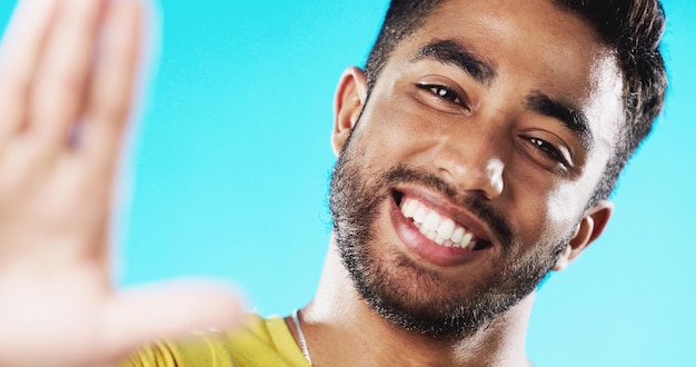 Foto selfie rindo e rosto de um homem com um sorriso isolado em um fundo azul em um estúdio feliz alegre e retrato de um jovem tirando uma foto sorrindo e posando para uma foto em um pano de fundo