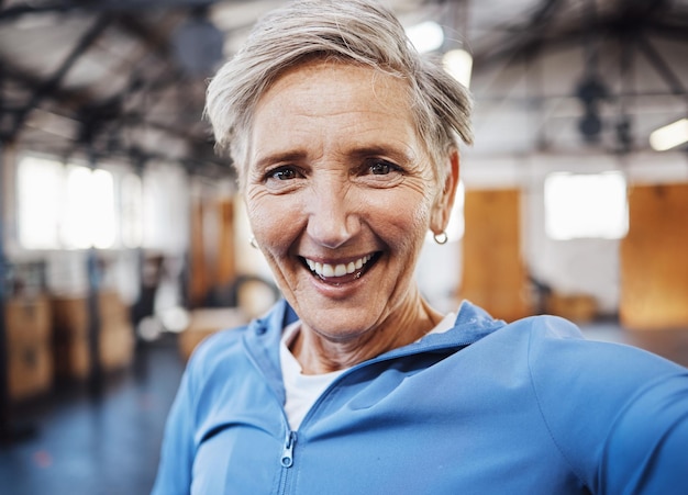 Selfie sonrisa y fitness mujer senior tomando fotos en el gimnasio después de hacer ejercicio o entrenar divirtiéndose Ancianos y retrato de mujer en forma feliz por el bienestar y la salud en las redes sociales