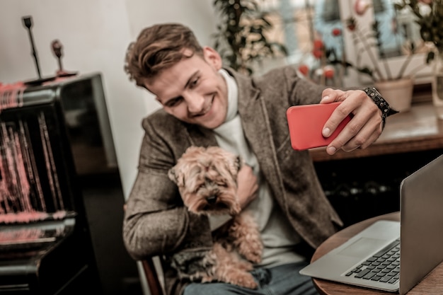 Selfie-Stern. Mann macht ein Selfie mit seinem kleinen Hund