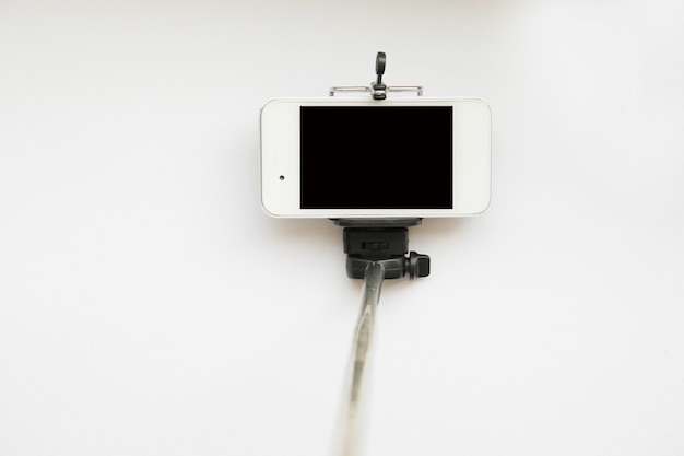 Selfie stick para smartphone aislado en blanco