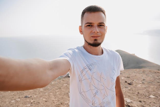 Selfieretrato de un joven turista masculino en el contexto de las montañas El concepto de turismo recreativo compartido