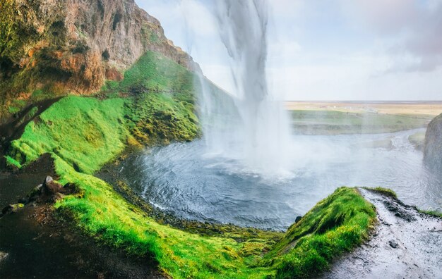 Foto seljalandfoss cachoeira ao pôr do sol. ponte sobre o rio. natureza fantástica. islândia