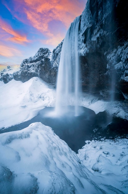 Seljalandsfoss liegt in der Südregion auf Island. Besucher können hinter dem Seljalandsfoss-Wasserfall mit einem großartigen Sonnenuntergang am beliebten Touristenziel Teil des Goldenen Kreises spazieren gehen