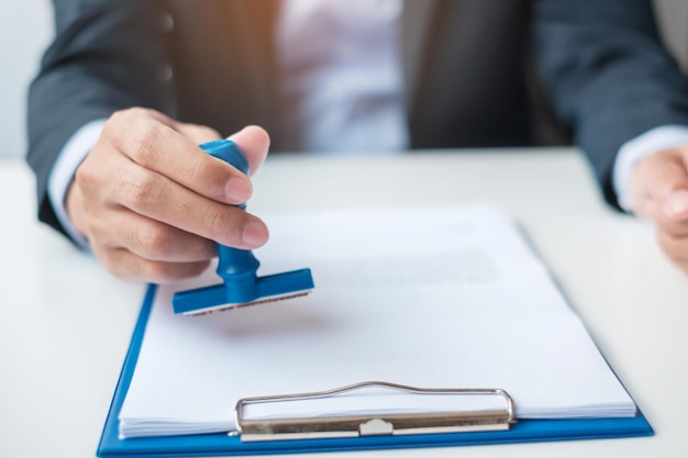 Sello de hombre de negocios durante la firma del documento del contrato Contrato comercial aprobar el acuerdo de contrato de asociación y los conceptos de garantía de calidad