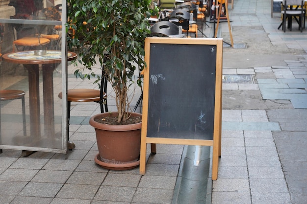 Sello de pizarra fuera de un café en una encantadora vista de la calle