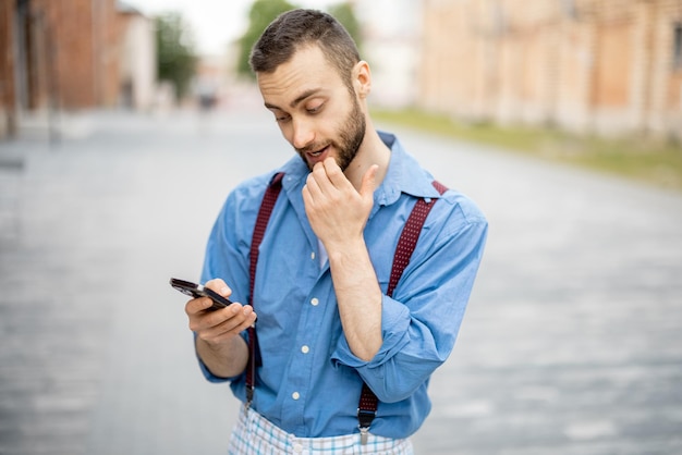 Seltsamer Geschäftsmann mit Telefon im Freien