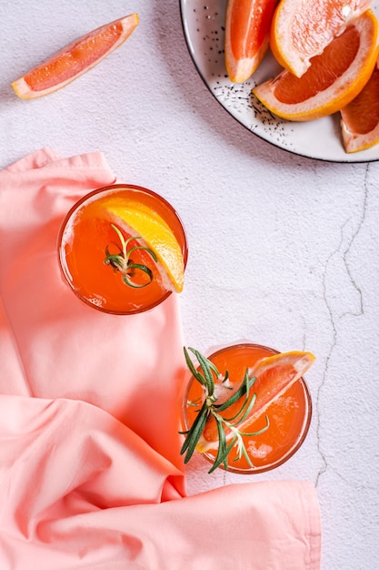 Seltzer duro com refrigerante de toranja e alecrim em copos no tampo da mesa e vista vertical