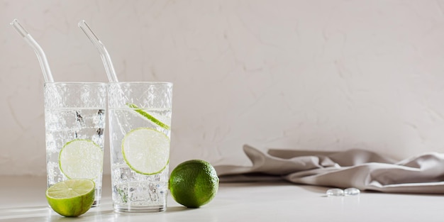 Seltzer duro con hielo y lima en vasos en el banner web de la mesa