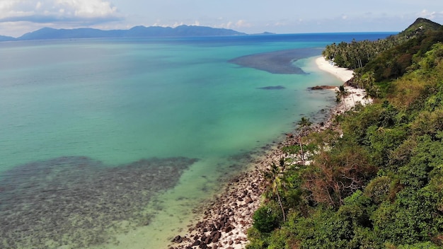 Selva verde e praia rochosa por mar ou oceano. Floresta tropical, costa arenosa da ilha paradisíaca.