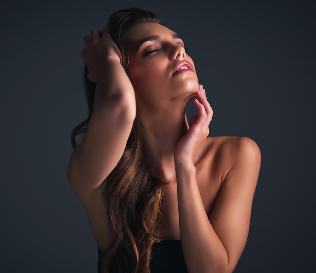 Sem fechar os olhos para sua beleza Foto de estúdio de uma jovem atraente posando contra um fundo escuro