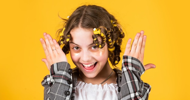 Sem penteado de calor garoto com manchas no rosto pose com rolos de cabelo garota feliz em rolos de cabelo jogando salão de cabeleireiro Dicas fáceis para fazer penteado para crianças ferramentas de cabeleireiro e acessórios para o cabelo