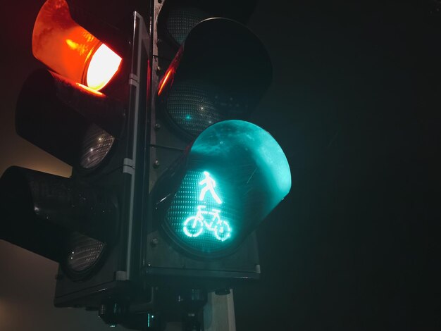 Semáforo de control de tráfico con luz verde por la noche