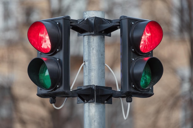 Foto semáforo de fundo da cidade de semáforo vermelho mostrando uma luz vermelha em ambas as direções, tudo é pro...