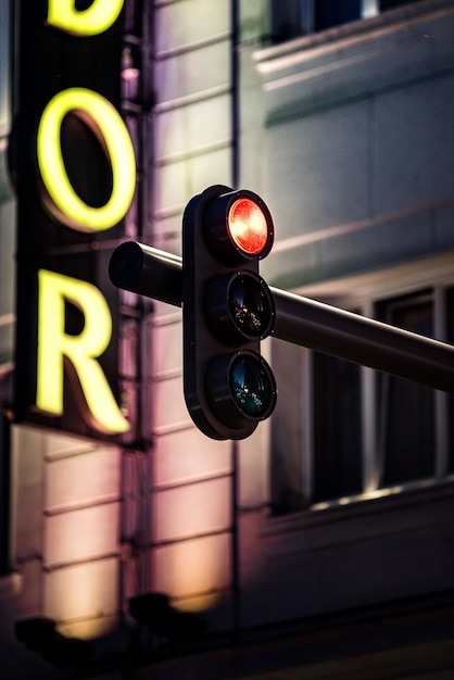 Foto semáforo moderno, mostrando a cor vermelha à noite em uma cidade moderna