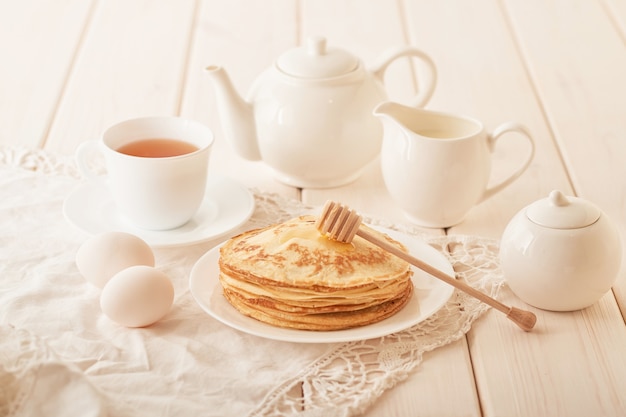 Semana da panqueca: panquecas com mel e chá na mesa