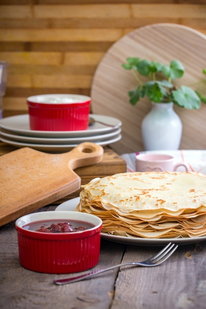 Semana de maslenitsa y panqueques. Plato lleno de panqueques de tradición rusa con crema agria en el platillo