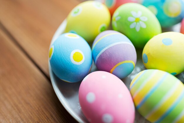 semana santa, vacaciones, tradición y concepto de objeto - cierre de huevos de pascua de colores en el plato