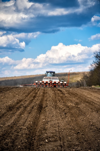 Foto semeando trabalho no campo. trator com semeadora.