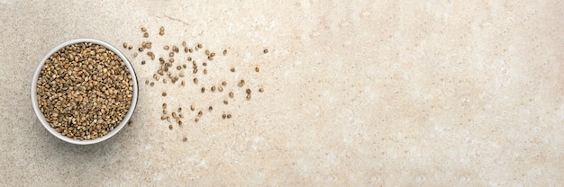 Sementes de cânhamo. sementes de cânhamo em um copo sobre uma mesa de mármore, vista superior. banner sobre o tema do cânhamo, com lugar para texto.