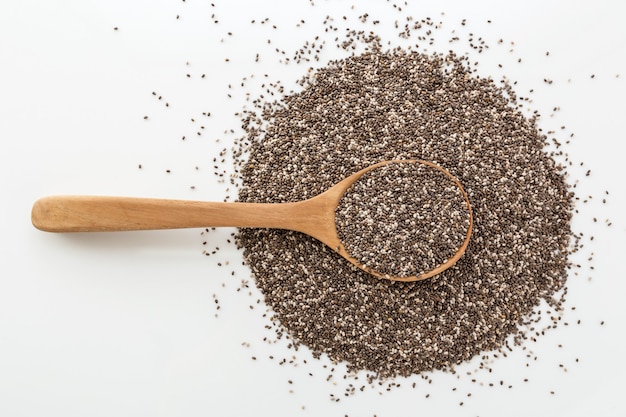 Sementes de Chia em colher de madeira no fundo branco