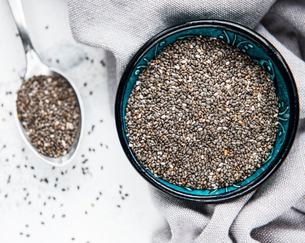 Sementes de chia em uma tigela na mesa de mármore branco.