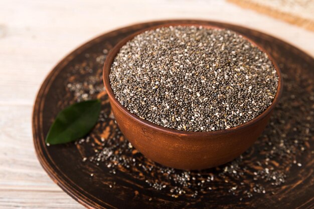 Sementes de chia em uma tigela sobre fundo colorido Salvia hispanica saudável em uma tigela pequena Superalimento saudável