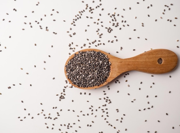 Sementes de chia saudáveis em uma colher de pau na mesa closeup