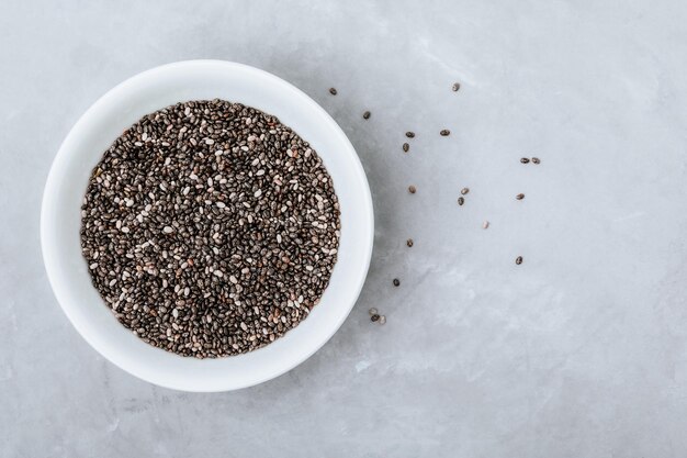 Sementes de Chia Sementes de Chia Preto e Branco Seco Orgânico em tigela sobre fundo de pedra cinza