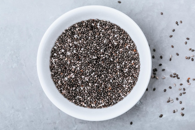 Sementes de Chia Sementes de Chia Preto e Branco Seco Orgânico em tigela sobre fundo de pedra cinza