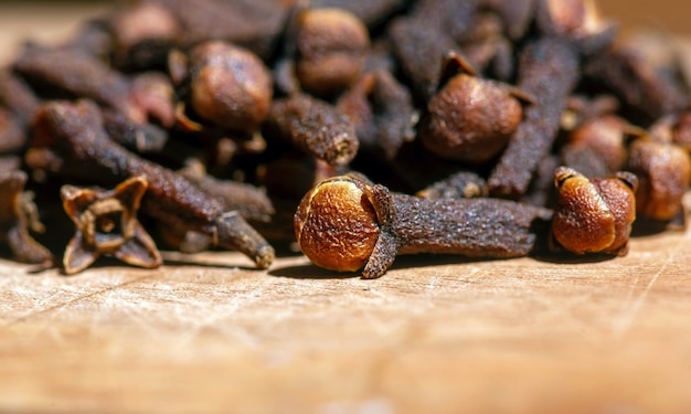 Sementes de cravo-da-índia secas, em foco raso, na mesa de madeira natural