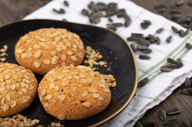 Sementes de girassol pretas com biscoitos colocados sobre uma mesa de madeira.