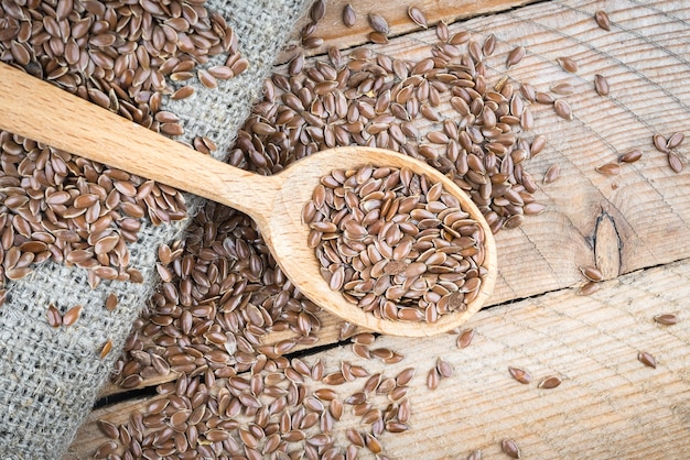 Sementes de linho em uma colher de pau em um pano de linho