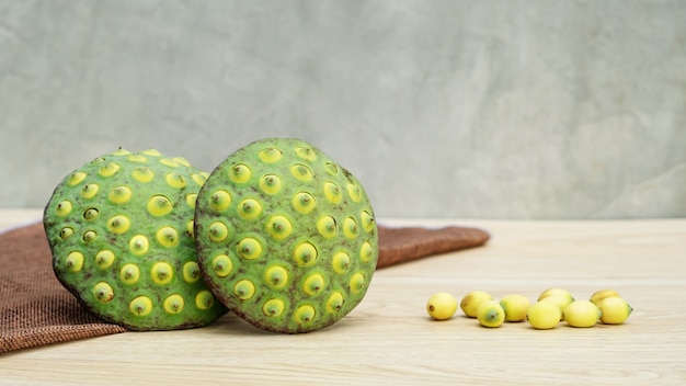 Foto sementes de lótus verdes em uma mesa de madeira.