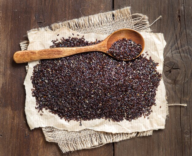 Sementes de psyllium com uma colher em uma mesa de madeira