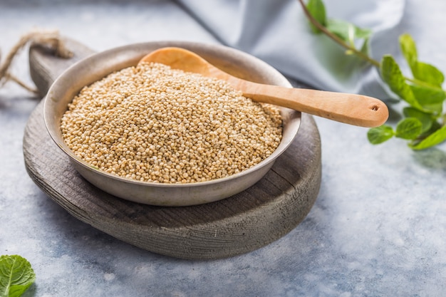 Foto sementes de quinoa branca crua no prato com colher de pau